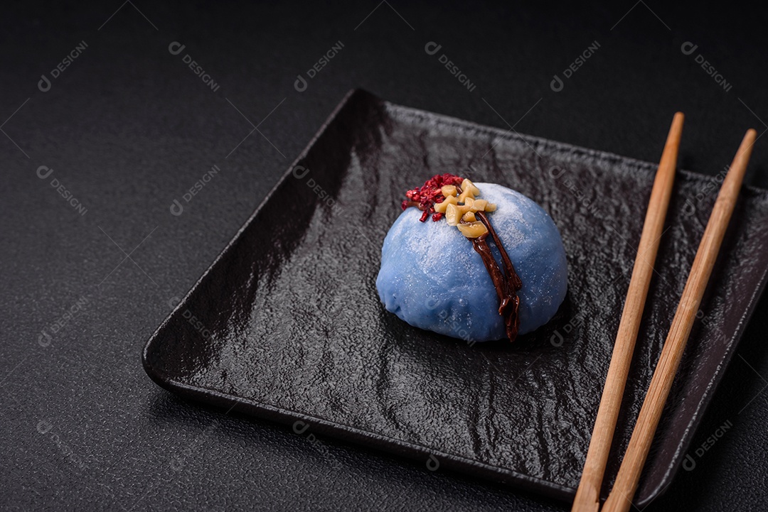 Deliciosas sobremesas mochi coloridas ou sorvete com massa de arroz e coberturas sobre um fundo escuro de concreto