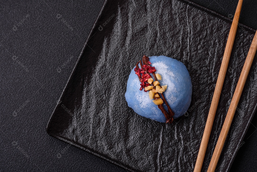 Deliciosas sobremesas mochi coloridas ou sorvete com massa de arroz e coberturas sobre um fundo escuro de concreto