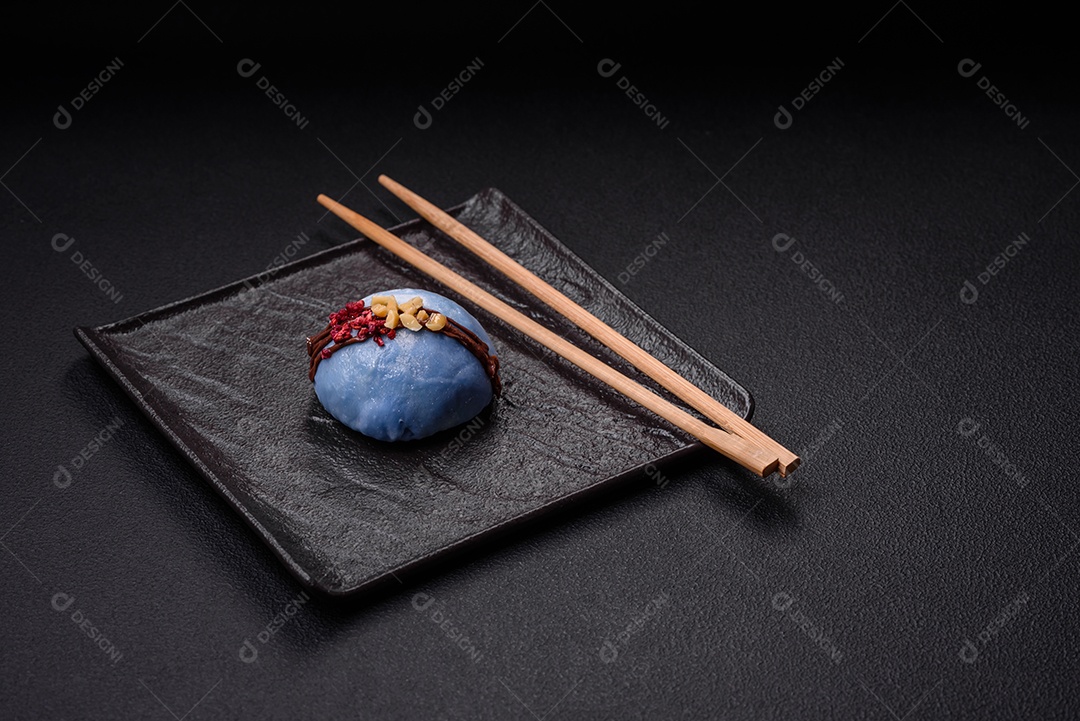 Deliciosas sobremesas mochi coloridas ou sorvete com massa de arroz e coberturas sobre um fundo escuro de concreto