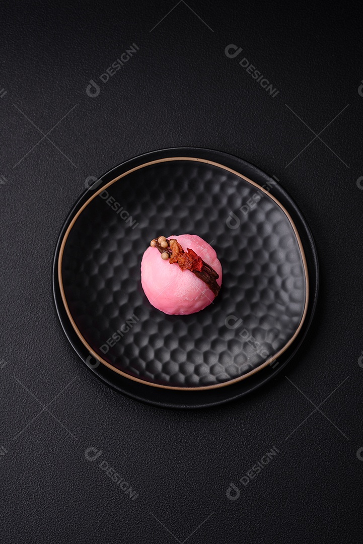 Deliciosas sobremesas mochi coloridas ou sorvete com massa de arroz e coberturas sobre um fundo escuro de concreto