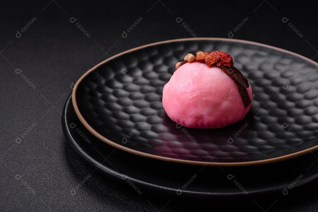 Deliciosas sobremesas mochi coloridas ou sorvete com massa de arroz e coberturas sobre um fundo escuro de concreto