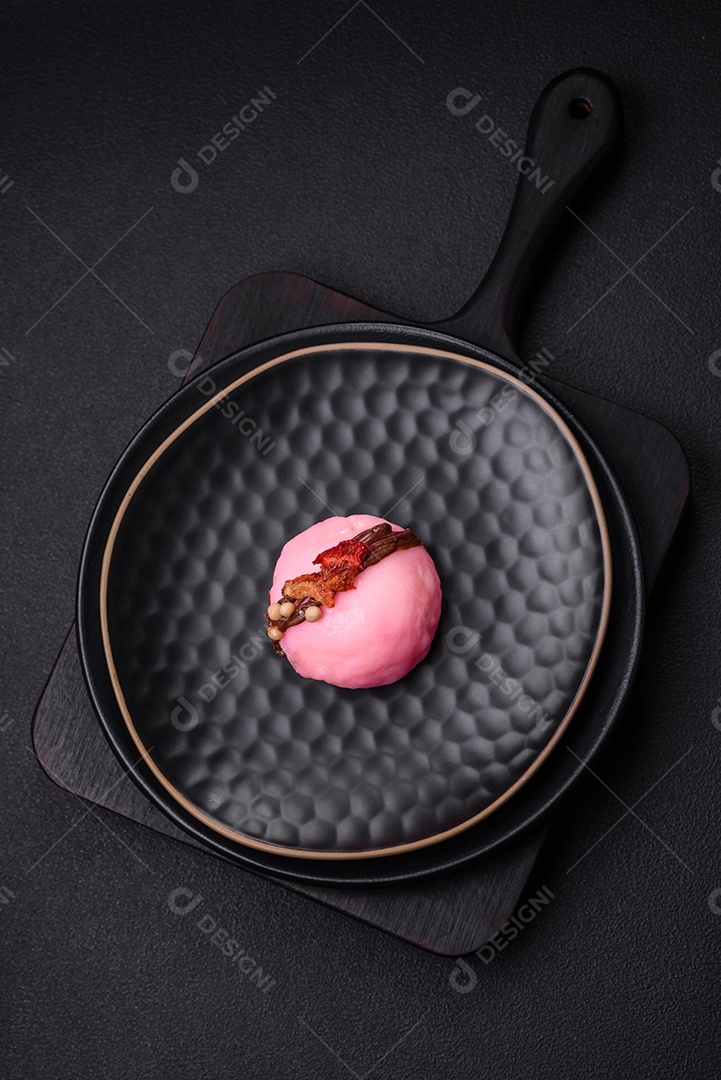 Deliciosas sobremesas mochi coloridas ou sorvete com massa de arroz e coberturas sobre um fundo escuro de concreto