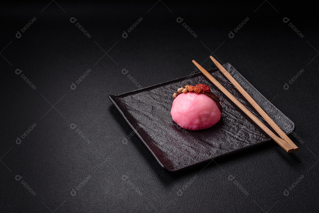 Deliciosas sobremesas mochi coloridas ou sorvete com massa de arroz e coberturas sobre um fundo escuro de concreto
