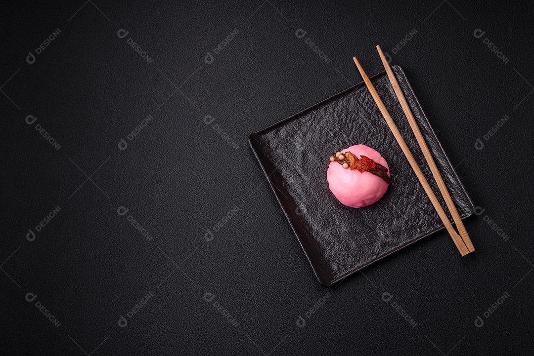Deliciosas sobremesas mochi coloridas ou sorvete com massa de arroz e coberturas sobre um fundo escuro de concreto