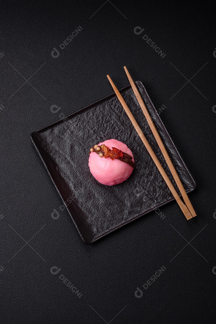 Deliciosas sobremesas mochi coloridas ou sorvete com massa de arroz e coberturas sobre um fundo escuro de concreto