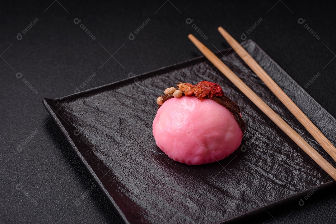 Deliciosas sobremesas mochi coloridas ou sorvete com massa de arroz e coberturas sobre um fundo escuro de concreto