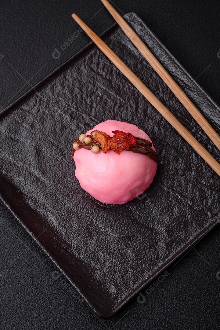 Deliciosas sobremesas mochi coloridas ou sorvete com massa de arroz e coberturas sobre um fundo escuro de concreto