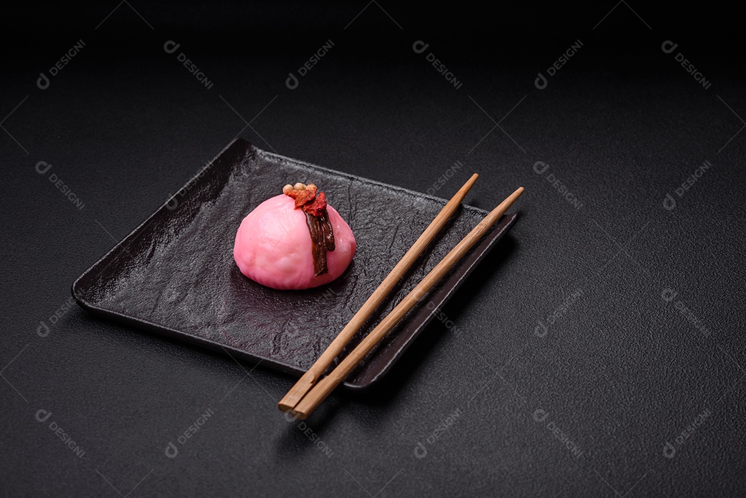 Deliciosas sobremesas mochi coloridas ou sorvete com massa de arroz e coberturas sobre um fundo escuro de concreto