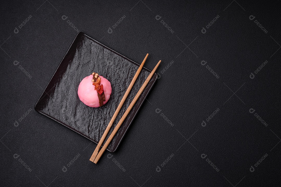 Deliciosas sobremesas mochi coloridas ou sorvete com massa de arroz e coberturas sobre um fundo escuro de concreto