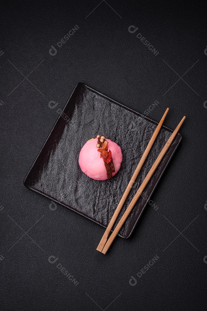 Deliciosas sobremesas mochi coloridas ou sorvete com massa de arroz e coberturas sobre um fundo escuro de concreto