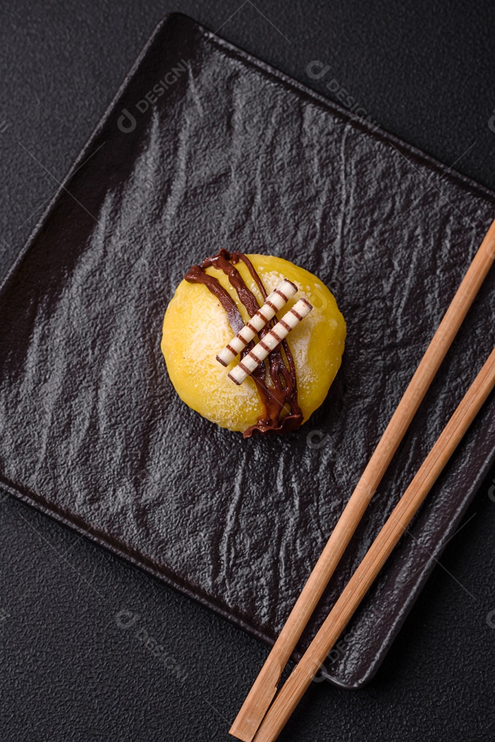Deliciosas sobremesas mochi coloridas ou sorvete com massa de arroz e coberturas sobre um fundo escuro de concreto
