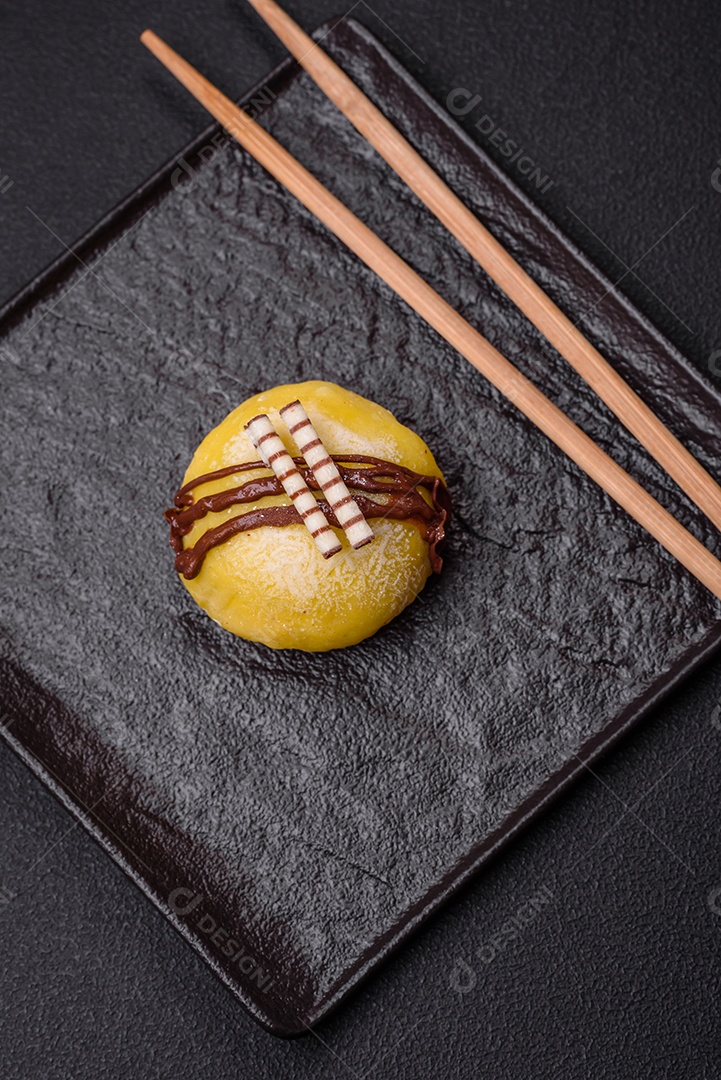 Deliciosas sobremesas mochi coloridas ou sorvete com massa de arroz e coberturas sobre um fundo escuro de concreto