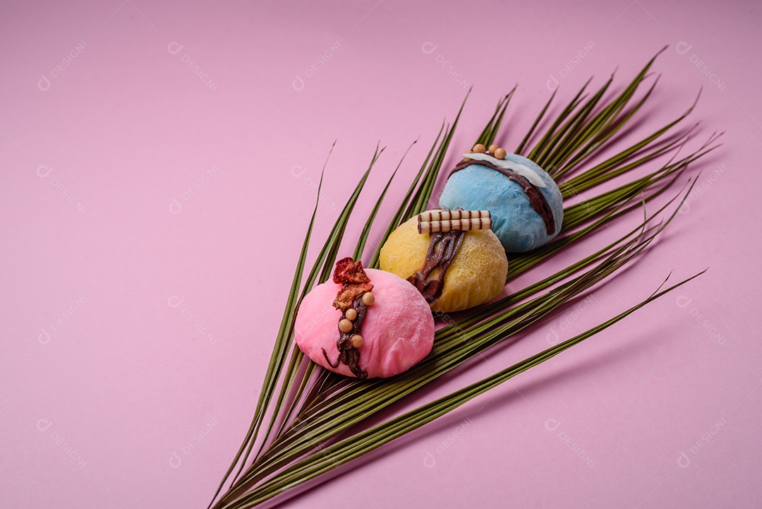 Deliciosas sobremesas mochi coloridas ou sorvete com massa de arroz e coberturas sobre um fundo escuro de concreto