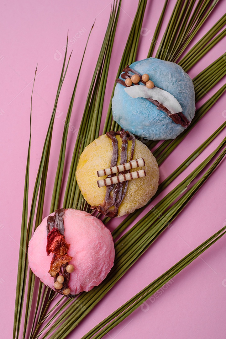 Deliciosas sobremesas mochi coloridas ou sorvete com massa de arroz e coberturas sobre um fundo escuro de concreto