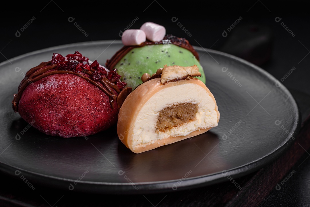 Deliciosas sobremesas mochi coloridas ou sorvete com massa de arroz e coberturas sobre um fundo escuro de concreto