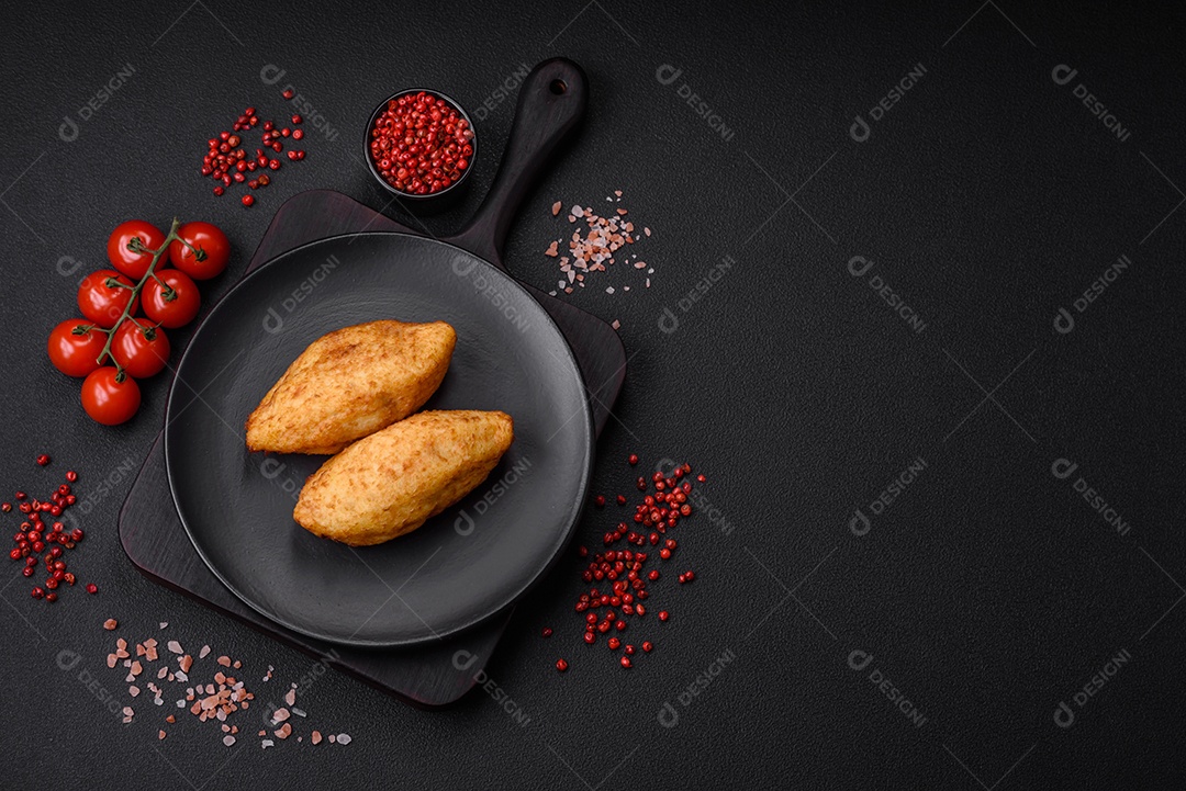 Deliciosa costeleta de batata assada recheada com frango e legumes, especiarias e sal sobre um fundo escuro de concreto