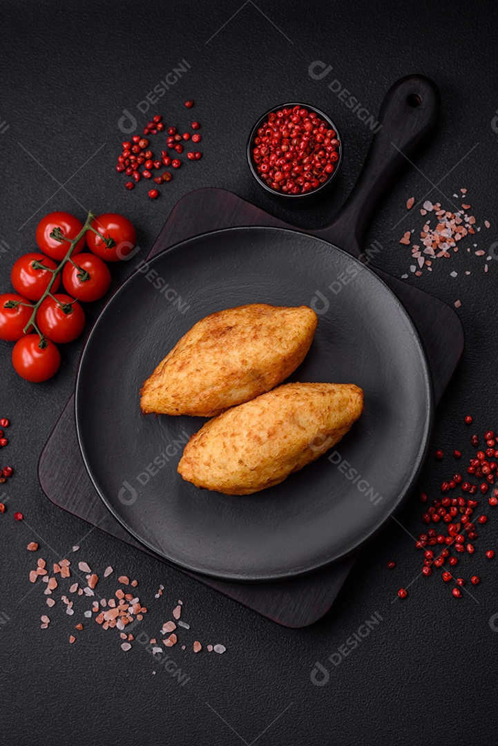 Deliciosa costeleta de batata assada recheada com frango e legumes, especiarias e sal sobre um fundo escuro de concreto