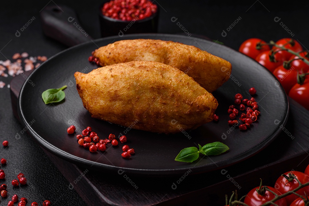 Deliciosa costeleta de batata assada recheada com frango e legumes, especiarias e sal sobre um fundo escuro de concreto