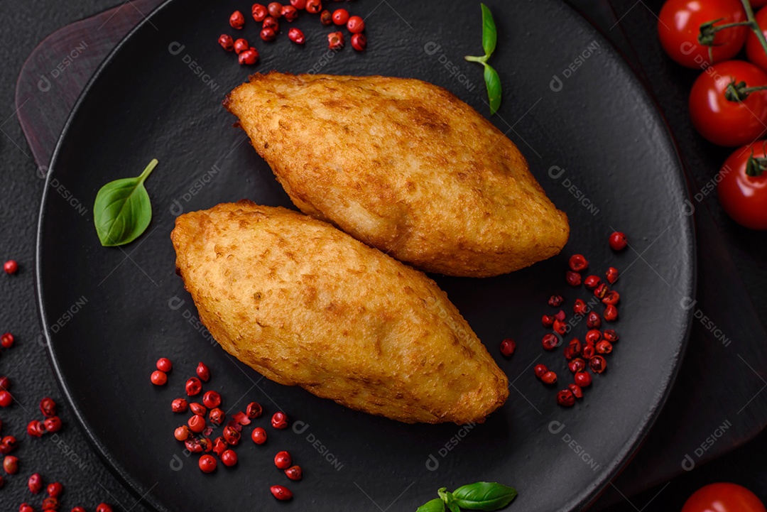 Deliciosa costeleta de batata assada recheada com frango e legumes, especiarias e sal sobre um fundo escuro de concreto