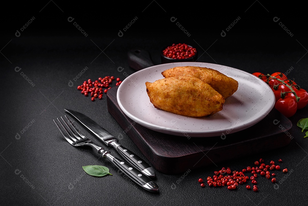 Deliciosa costeleta de batata assada recheada com frango e legumes, especiarias e sal sobre um fundo escuro de concreto