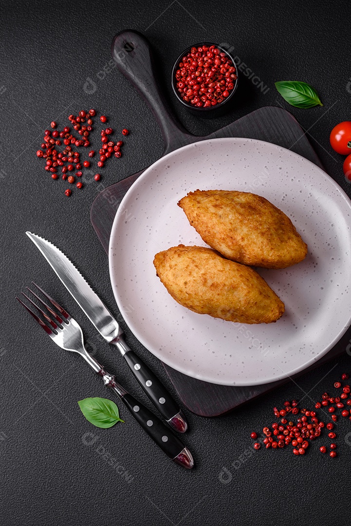 Deliciosa costeleta de batata assada recheada com frango e legumes, especiarias e sal sobre um fundo escuro de concreto