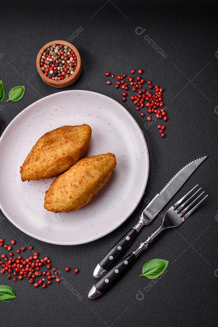 Deliciosa costeleta de batata assada recheada com frango e legumes, especiarias e sal sobre um fundo escuro de concreto