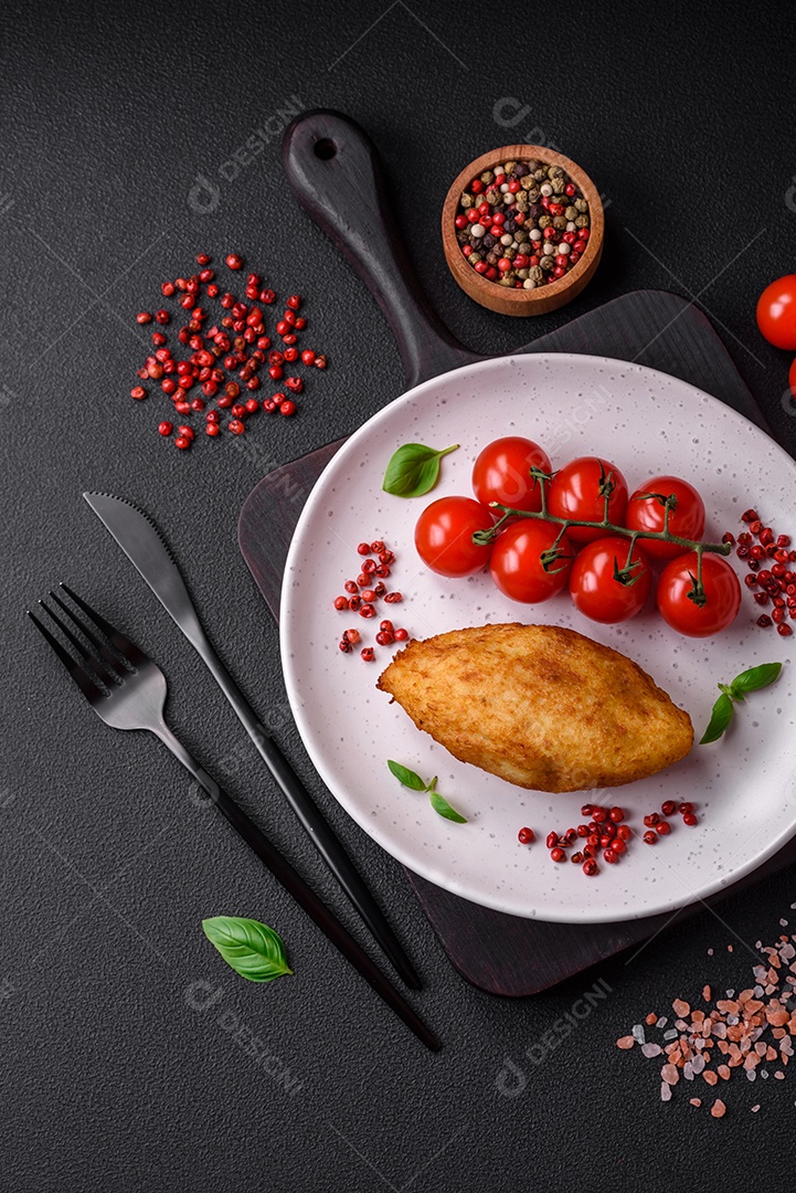 Deliciosa costeleta de batata assada recheada com frango e legumes, especiarias e sal sobre um fundo escuro de concreto