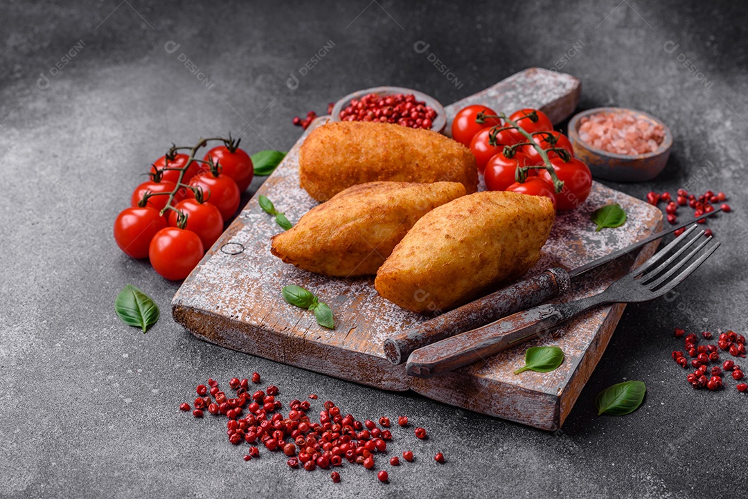Deliciosa costeleta de batata assada recheada com frango e legumes, especiarias e sal sobre um fundo escuro de concreto