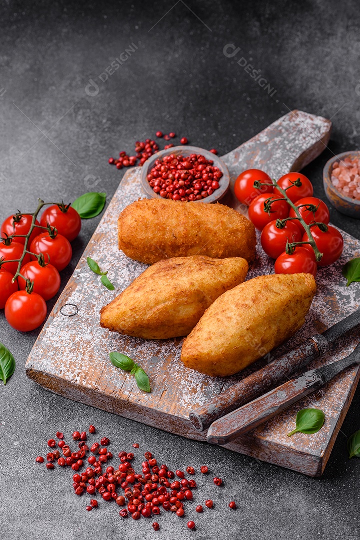 Deliciosa costeleta de batata assada recheada com frango e legumes, especiarias e sal sobre um fundo escuro de concreto