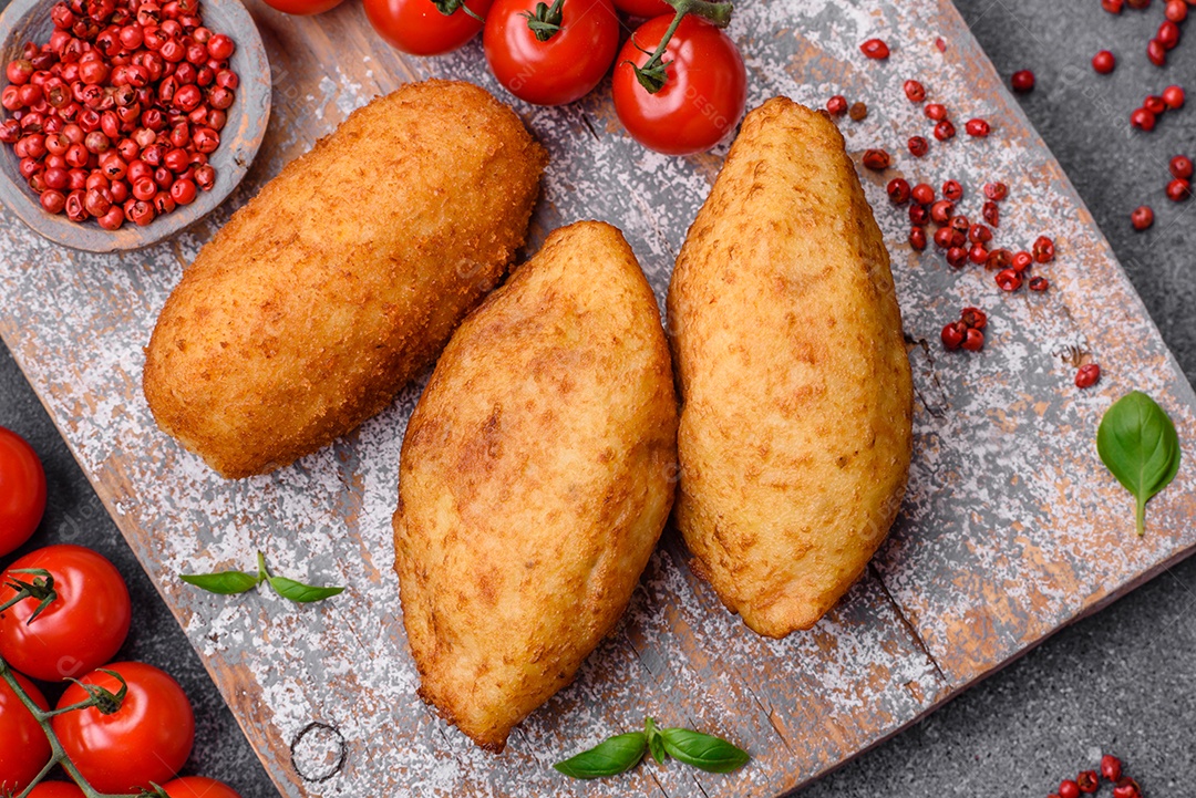 Deliciosa costeleta de batata assada recheada com frango e legumes, especiarias e sal sobre um fundo escuro de concreto