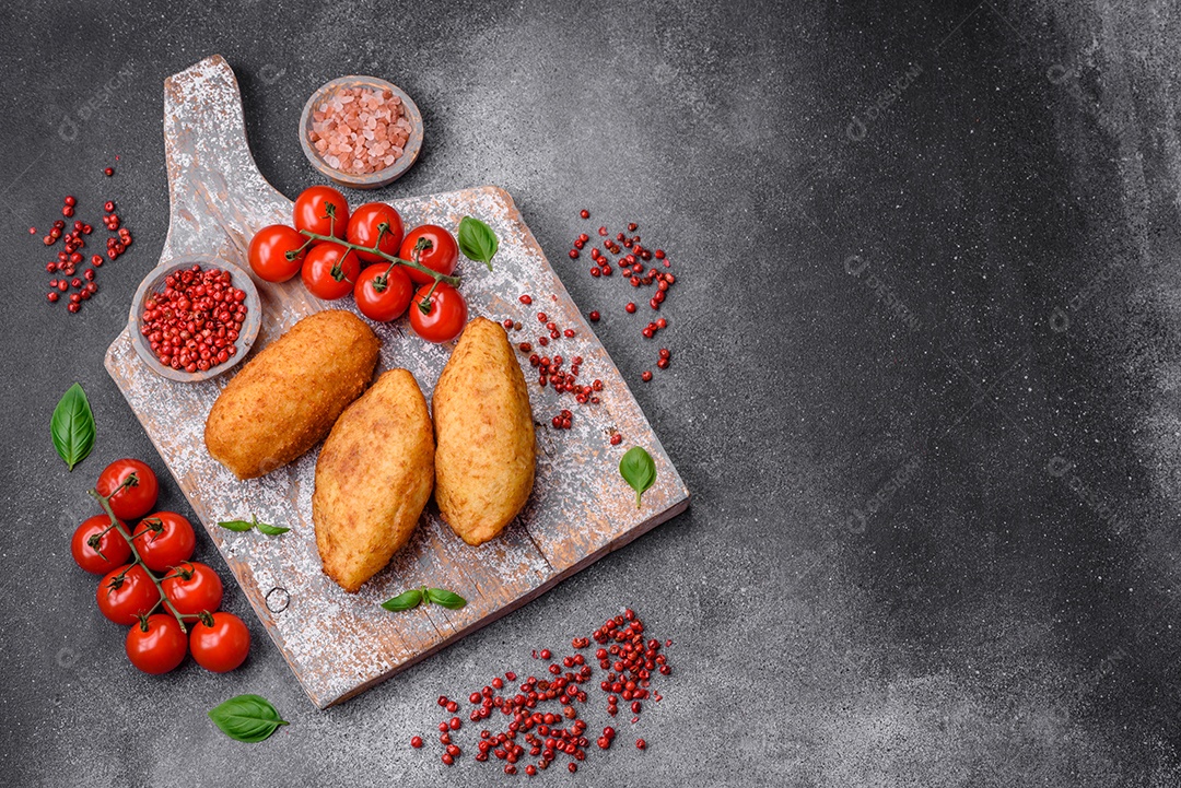 Deliciosa costeleta de batata assada recheada com frango e legumes, especiarias e sal sobre um fundo escuro de concreto