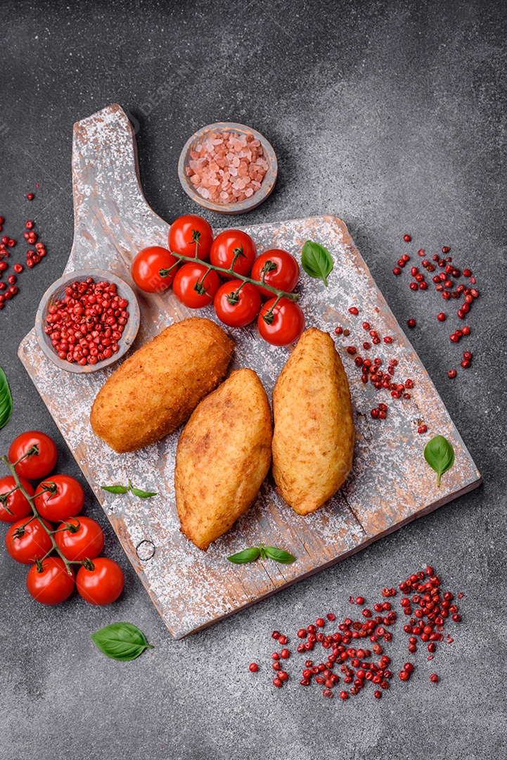 Deliciosa costeleta de batata assada recheada com frango e legumes, especiarias e sal sobre um fundo escuro de concreto