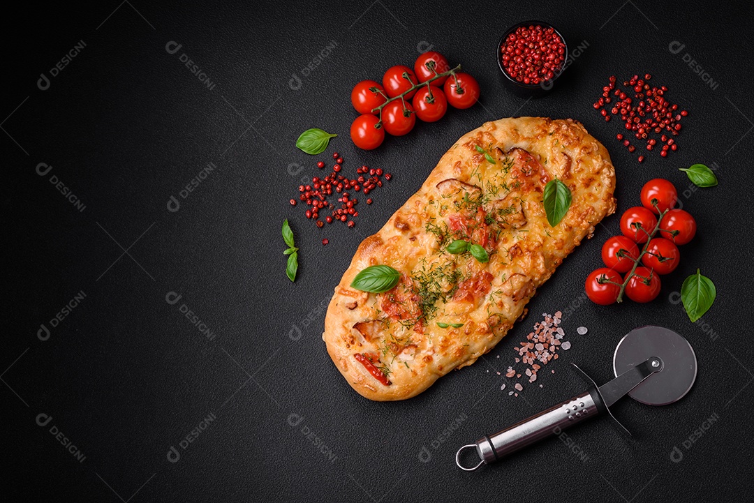 Deliciosa pizza de pão achatado fresco com queijo, tomate, salsicha, sal e especiarias sobre um fundo escuro de concreto