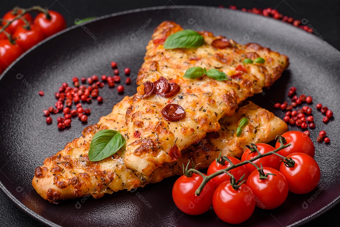 Deliciosa pizza de pão achatado fresco com queijo, tomate, salsicha, sal e especiarias sobre um fundo escuro de concreto