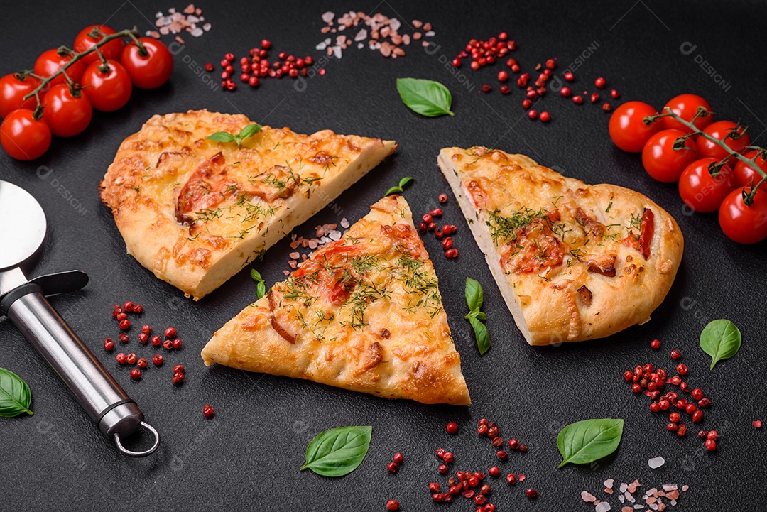 Deliciosa pizza de pão achatado fresco com queijo, tomate, salsicha, sal e especiarias sobre um fundo escuro de concreto