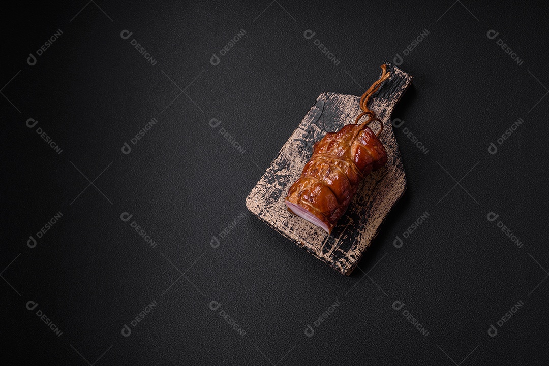 Delicioso bacon defumado com sal, especiarias e ervas sobre um fundo escuro de concreto