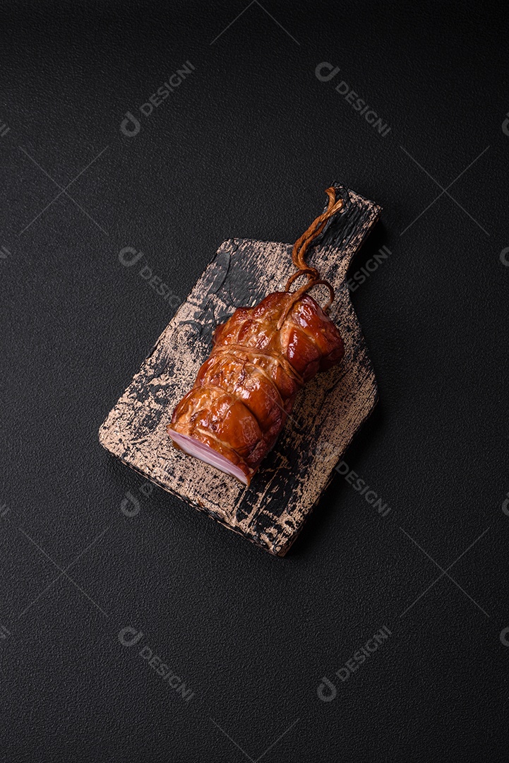 Delicioso bacon defumado com sal, especiarias e ervas sobre um fundo escuro de concreto