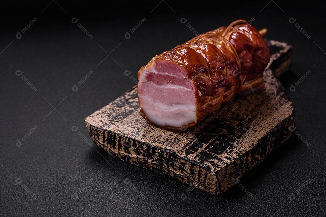 Delicioso bacon defumado com sal, especiarias e ervas sobre um fundo escuro de concreto