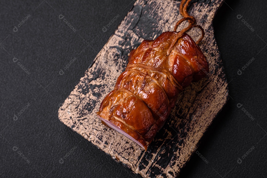 Delicioso bacon defumado com sal, especiarias e ervas sobre um fundo escuro de concreto