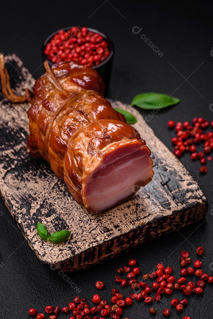 Delicioso bacon defumado com sal, especiarias e ervas sobre um fundo escuro de concreto