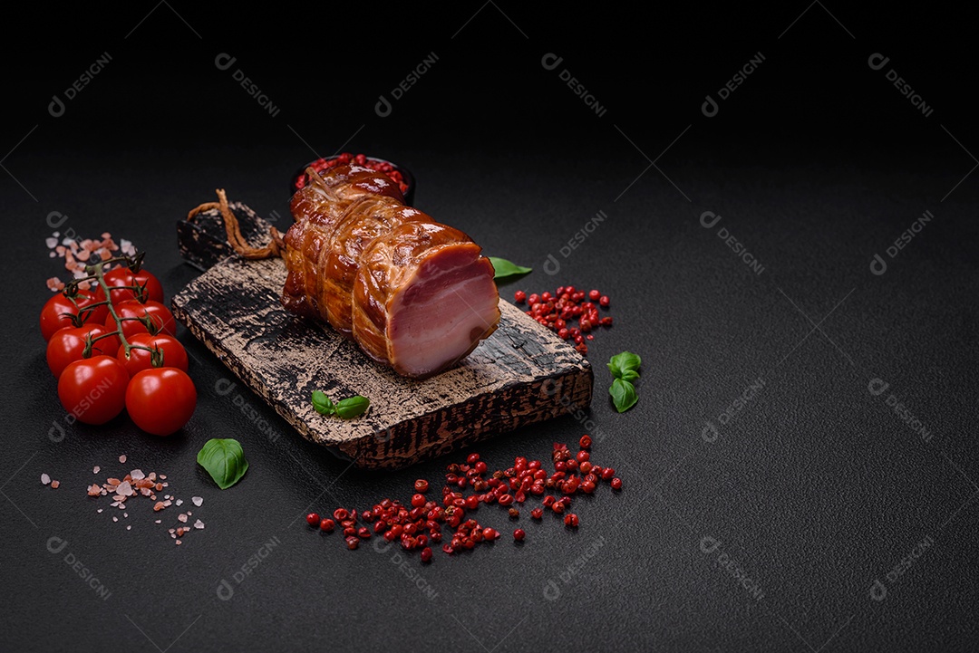 Delicioso bacon defumado com sal, especiarias e ervas sobre um fundo escuro de concreto