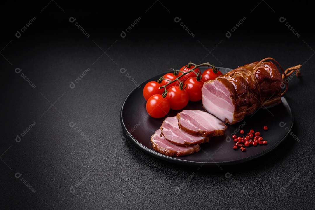 Delicioso bacon defumado com sal, especiarias e ervas sobre um fundo escuro de concreto