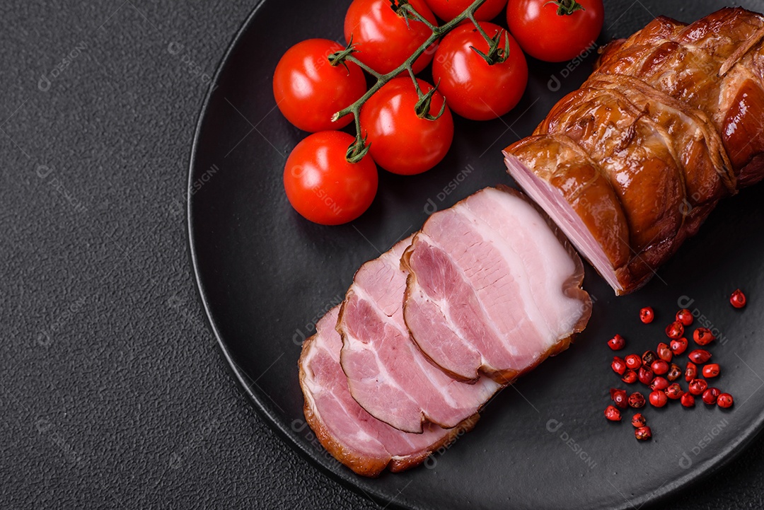 Delicioso bacon defumado com sal, especiarias e ervas sobre um fundo escuro de concreto