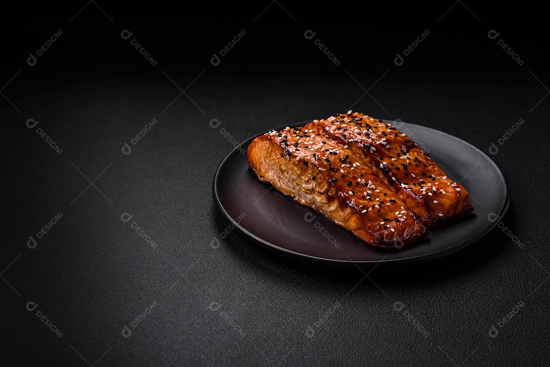 Delicioso peixe vermelho grelhado fresco com sal, especiarias e ervas sobre um fundo escuro de concreto