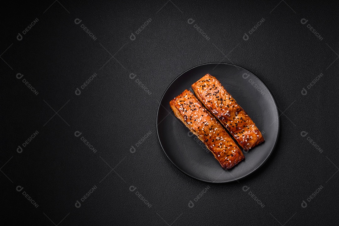 Delicioso peixe vermelho grelhado fresco com sal, especiarias e ervas sobre um fundo escuro de concreto