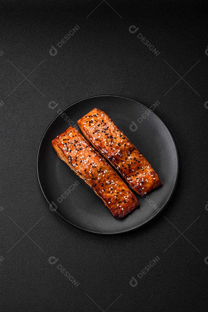 Delicioso peixe vermelho grelhado fresco com sal, especiarias e ervas sobre um fundo escuro de concreto