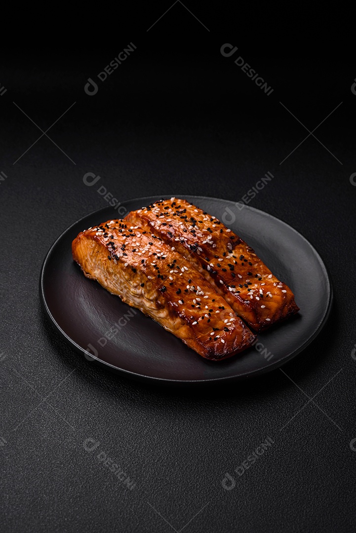 Delicioso peixe vermelho grelhado fresco com sal, especiarias e ervas sobre um fundo escuro de concreto