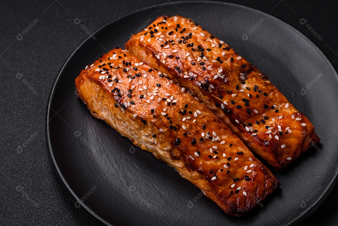 Delicioso peixe vermelho grelhado fresco com sal, especiarias e ervas sobre um fundo escuro de concreto