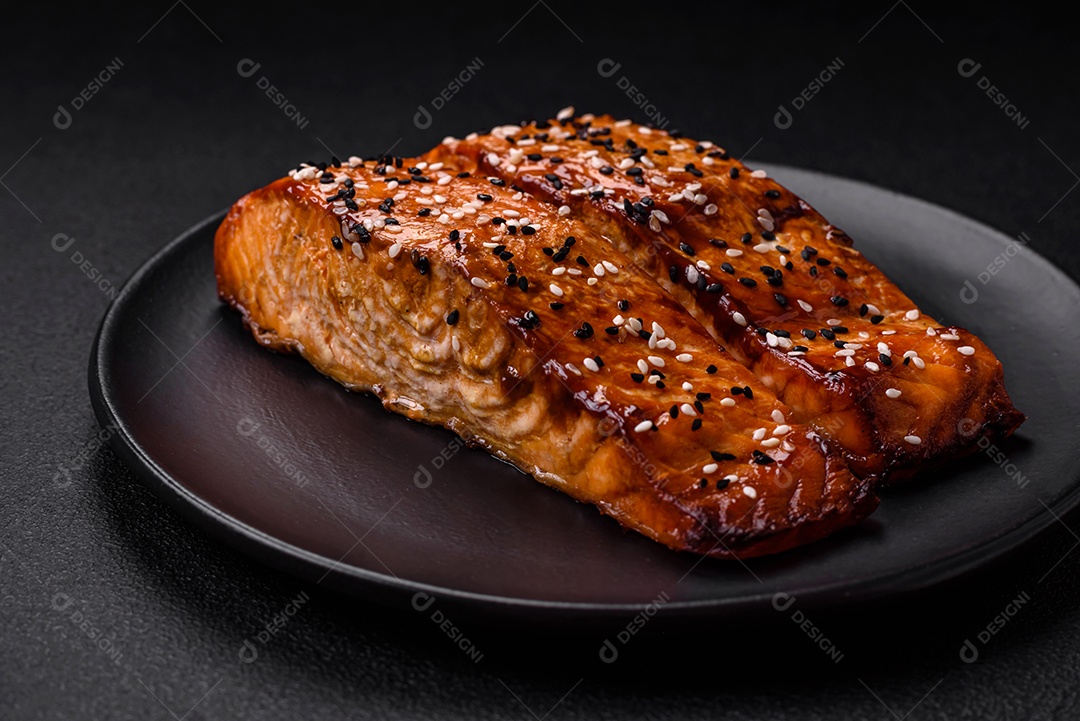 Delicioso peixe vermelho grelhado fresco com sal, especiarias e ervas sobre um fundo escuro de concreto