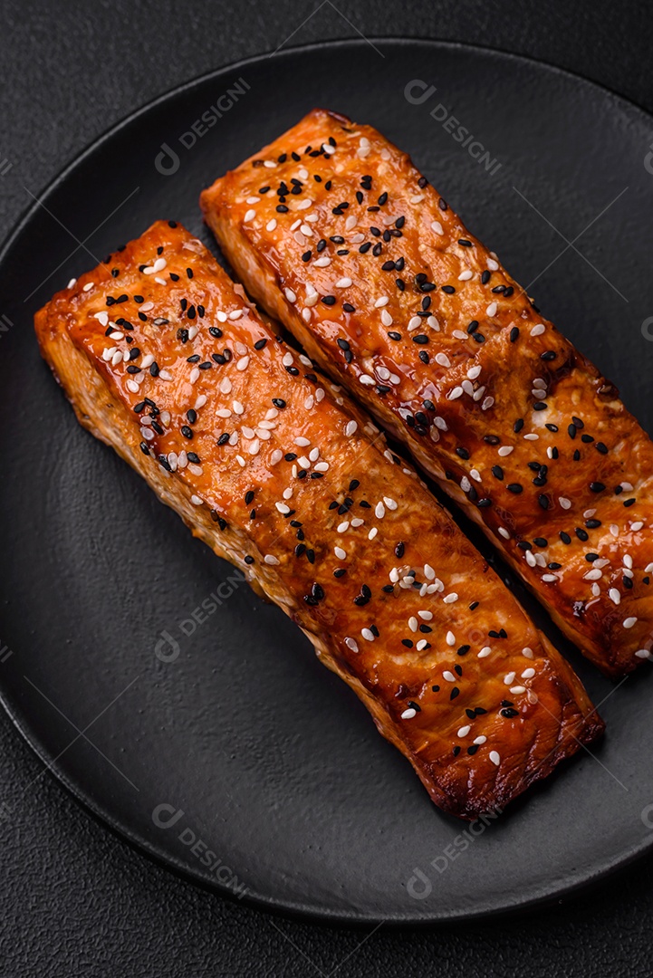 Delicioso peixe vermelho grelhado fresco com sal, especiarias e ervas sobre um fundo escuro de concreto